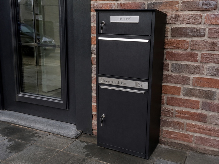 BunnyBox parcel letterbox against a brick facade next to a window, close-up